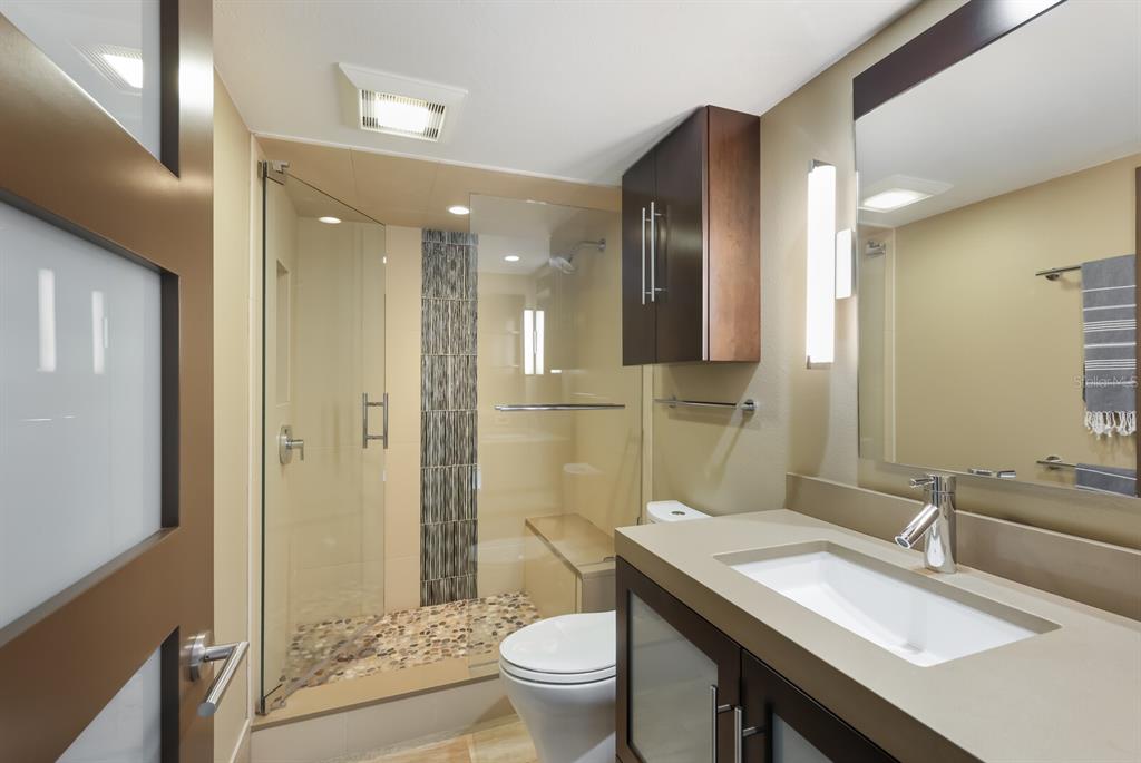 11000 Placida Road, Unit 2203 Placida, FL 33946 - Photo 32 of 64 a bathroom with a sink a toilet a large mirror and shower