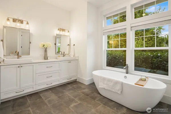 a spacious bathroom with a tub sink and mirror