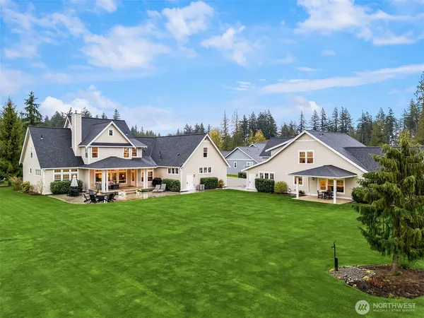 a view of a house with a big yard and large trees