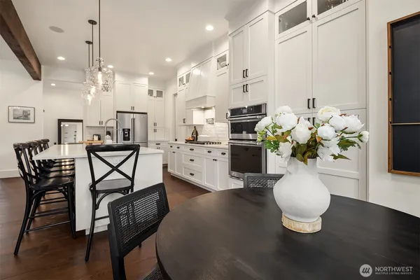 a dining room filled chandelier and kitchen view