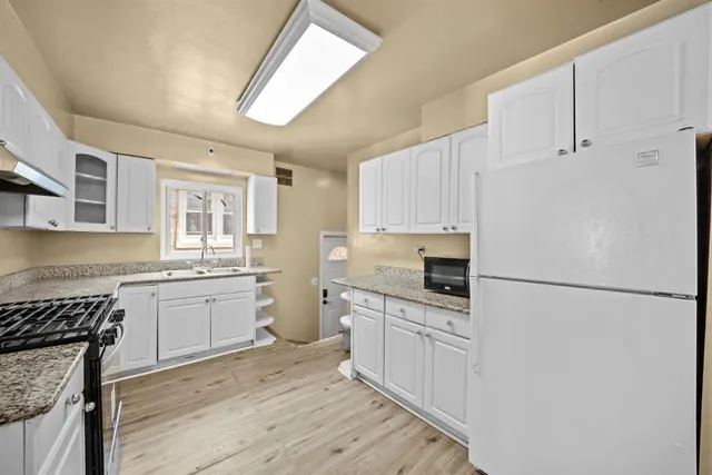 a kitchen with white cabinets and white appliances