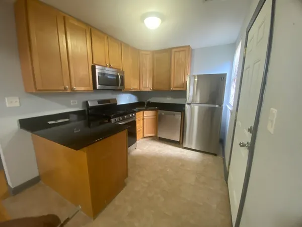 a kitchen with stainless steel appliances granite countertop a refrigerator a sink a stove a microwave and island