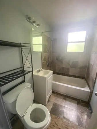 a white toilet sitting next to a bath tub and a shower