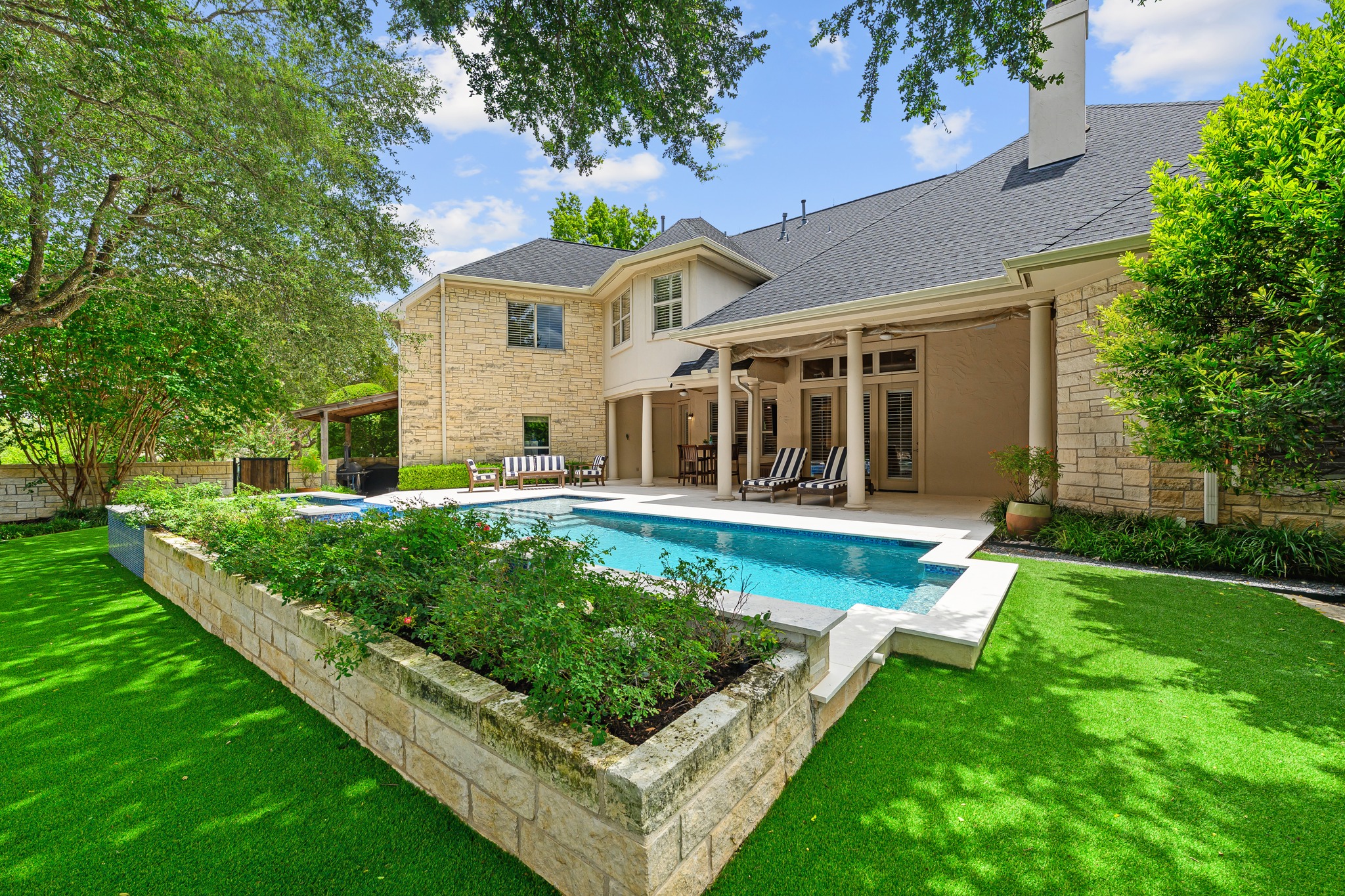 5200 Rico Cove Austin, TX 78731 - Photo 33 of 40 Manicured lawns surround an inviting swimming pool bordering a covered stone terrace.