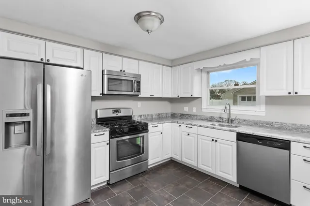 a kitchen with stainless steel appliances granite countertop a stove a sink and a refrigerator
