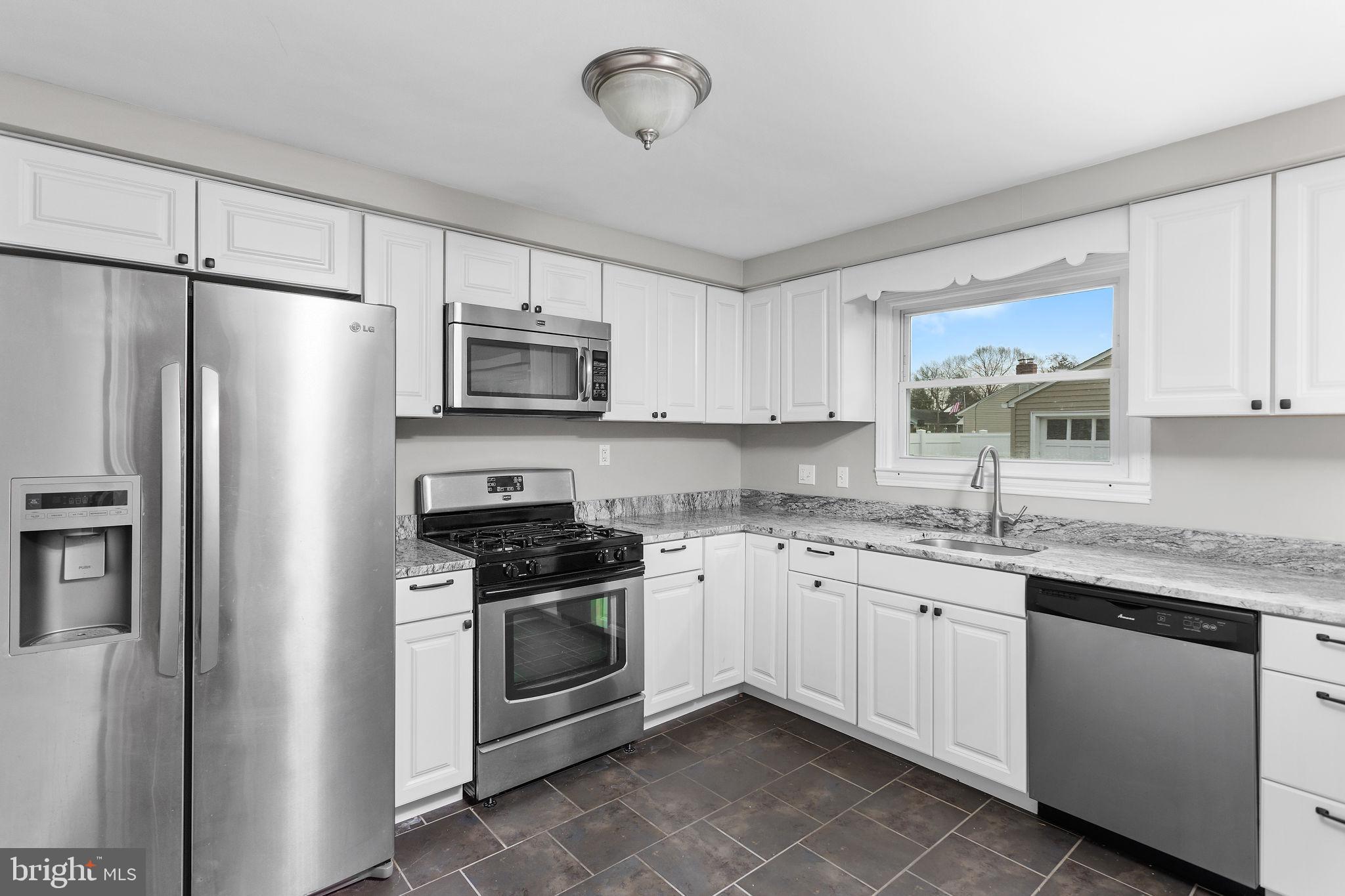 81 Wittenborn Avenue Hamilton, NJ 08619 - Photo 7 of 24 a kitchen with stainless steel appliances granite countertop a stove a sink and a refrigerator
