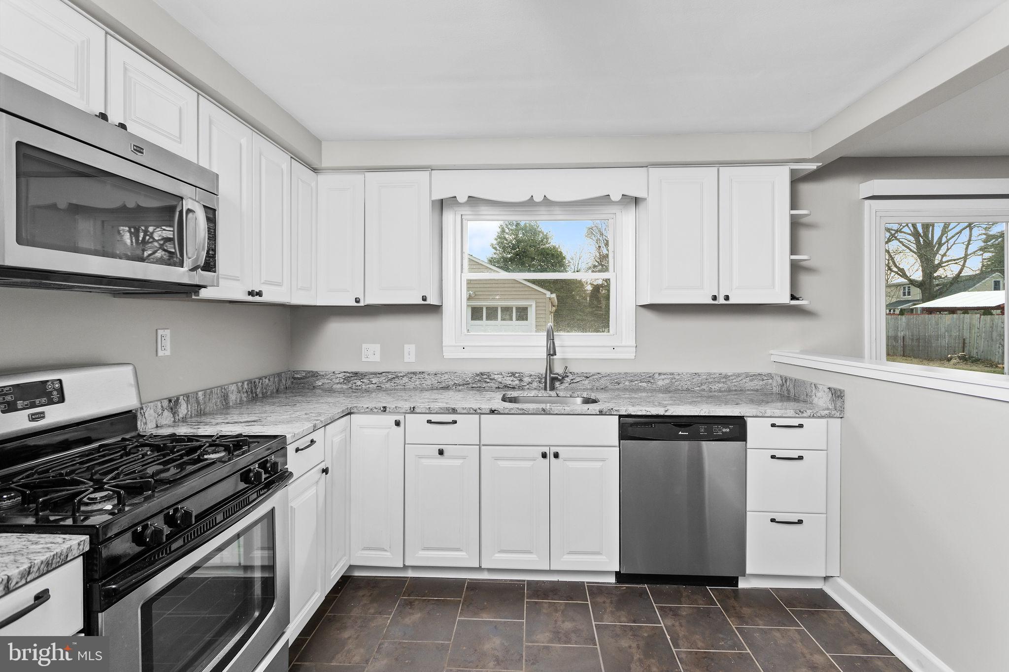 81 Wittenborn Avenue Hamilton, NJ 08619 - Photo 8 of 24 a kitchen with stainless steel appliances granite countertop a stove a sink and a microwave