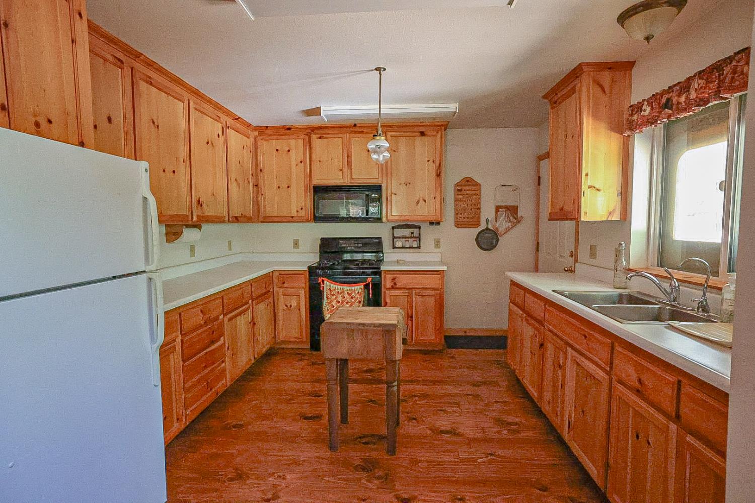 67922 Beasore Road Bass Lake, CA 93604 - Photo 14 of 39 a kitchen with stainless steel appliances kitchen island granite countertop a refrigerator a stove top oven a sink and dishwasher