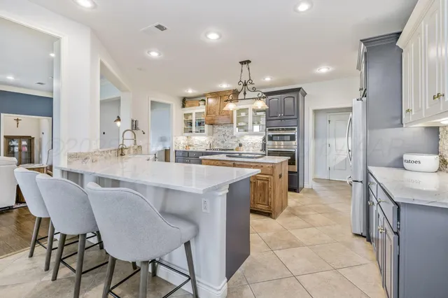 a spacious bedroom with a bed and a chandelier