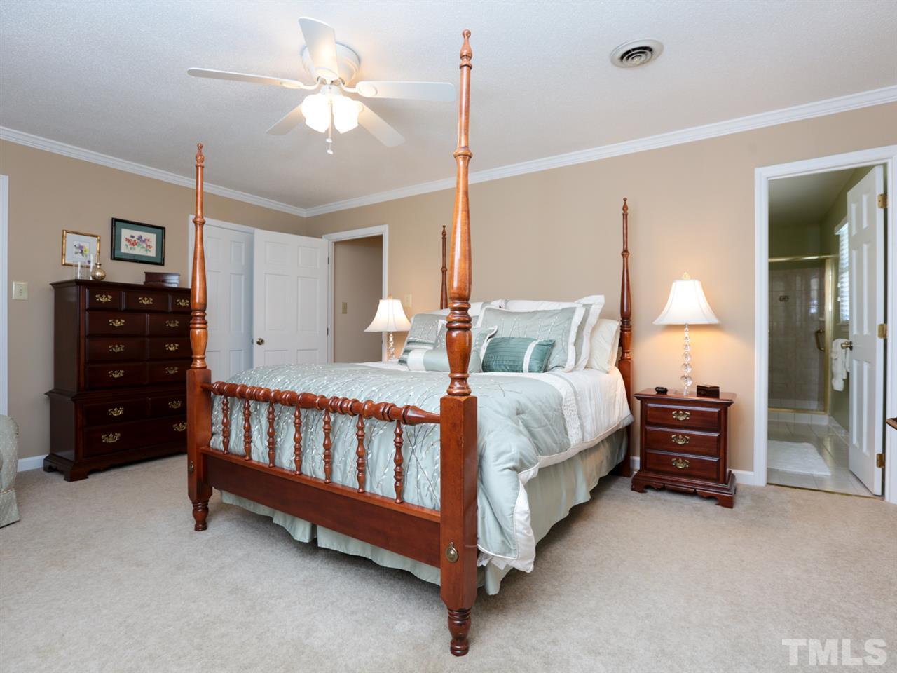 1413 Pony Run Road Raleigh, NC 27615 - Photo 18 of 25 a spacious bedroom with a bed and a lamp