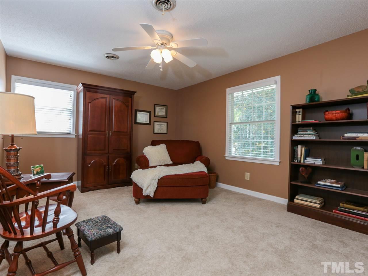 1413 Pony Run Road Raleigh, NC 27615 - Photo 20 of 25 a bedroom with a bed and a chandelier
