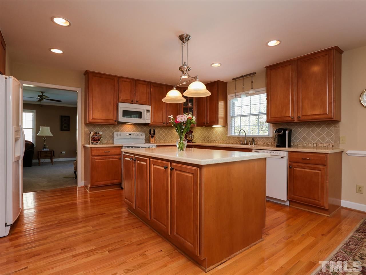1413 Pony Run Road Raleigh, NC 27615 - Photo 6 of 25 a kitchen with kitchen island granite countertop wooden floors granite counter tops and a window