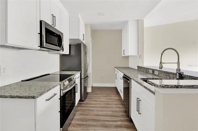 a kitchen with granite countertop stainless steel appliances and a sink