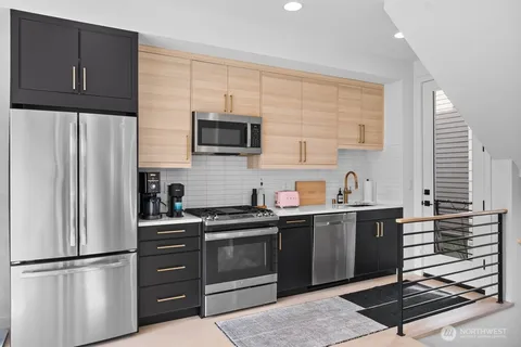 a kitchen with stainless steel appliances a refrigerator sink and microwave