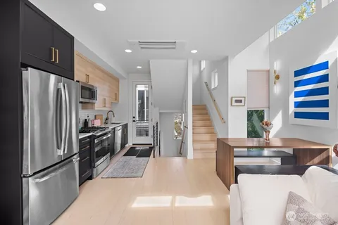 a kitchen with stainless steel appliances kitchen island granite countertop a refrigerator a stove and a sink
