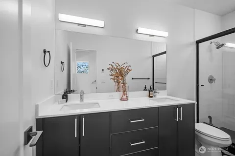 a bathroom with a double vanity sink toilet and mirror
