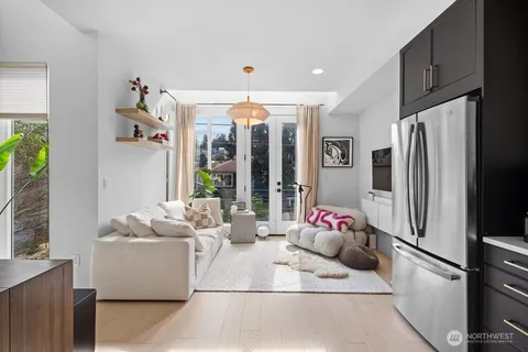 a living room with furniture and a refrigerator