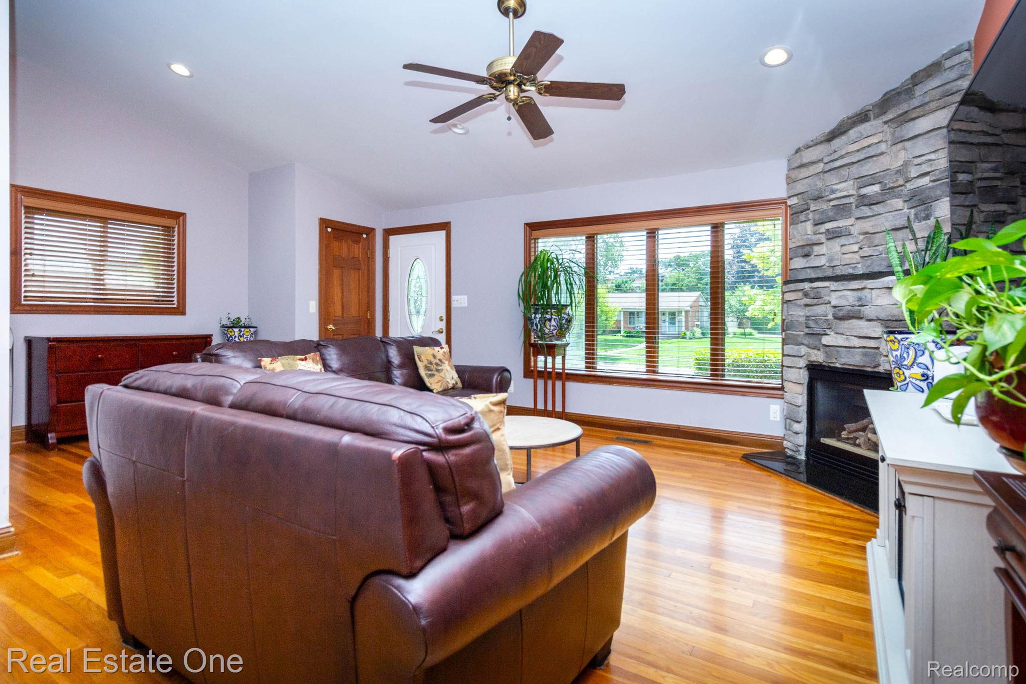 220 Winry Drive Rochester, MI 48307 - Photo 15 of 35 Living area with wood-finish flooring, vaulted ceilings, recessed lighting, and a stone-clad fireplace