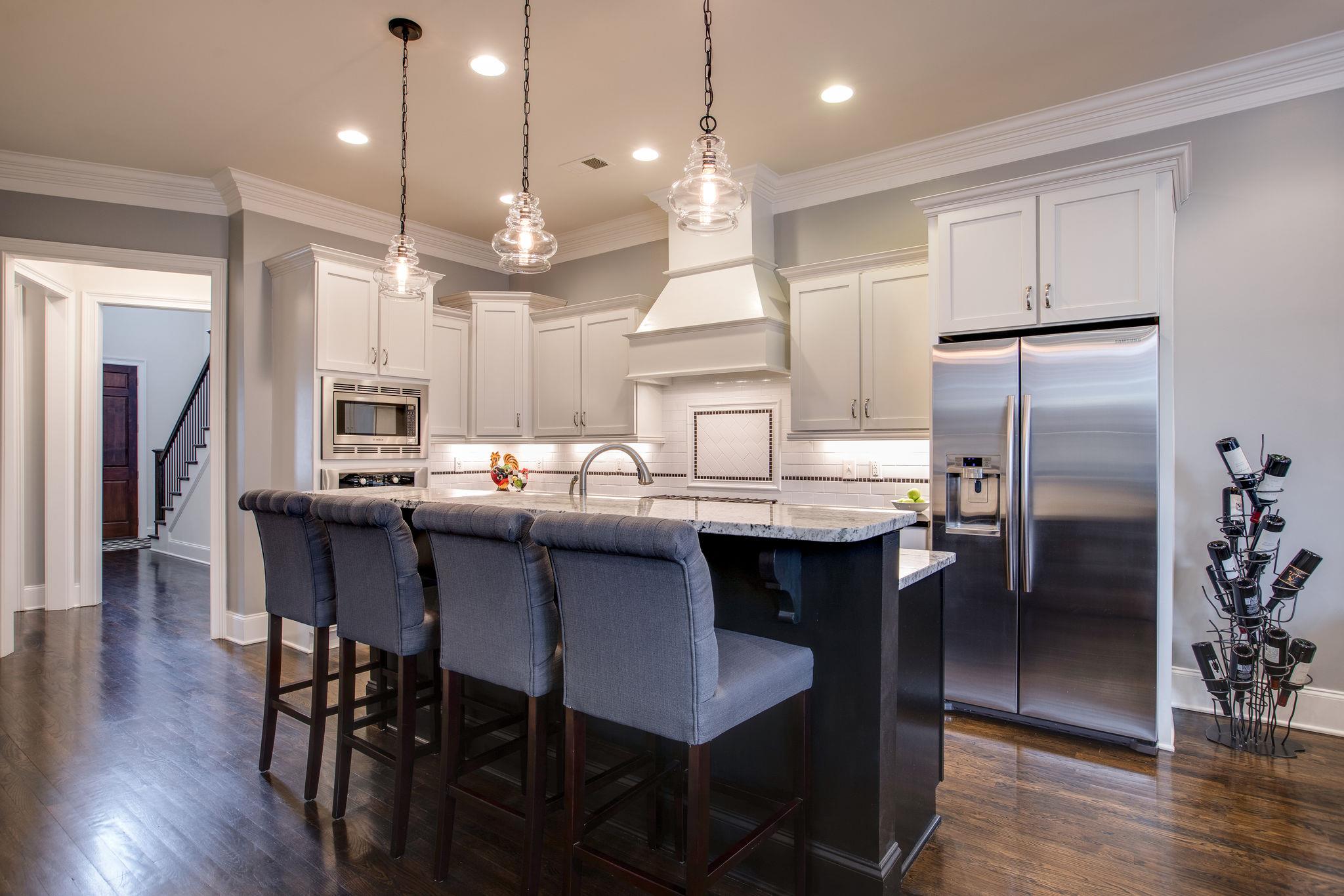 1367 Eliot Road Franklin, TN 37064 - Photo 5 of 30 a kitchen with stainless steel appliances granite countertop a table chairs refrigerator and sink