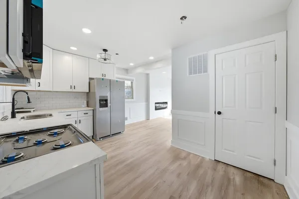 a kitchen with stainless steel appliances a refrigerator sink and white cabinets