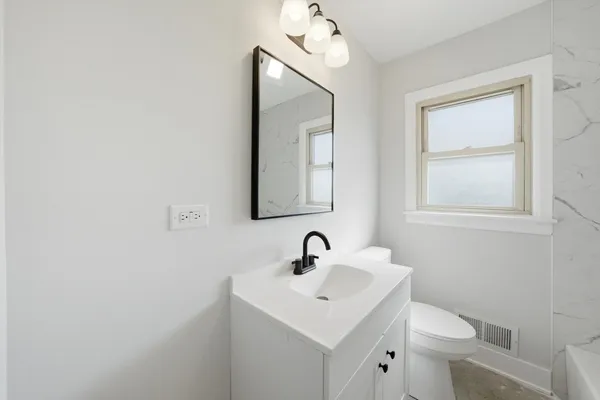 a bathroom with a toilet sink and mirror