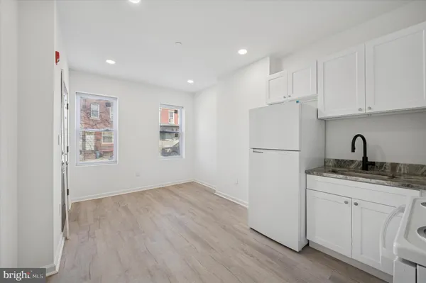 a kitchen with a refrigerator sink and cabinets