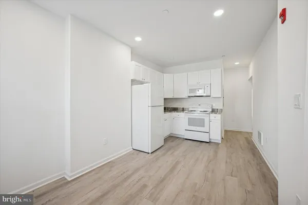 a kitchen with white cabinets and white appliances