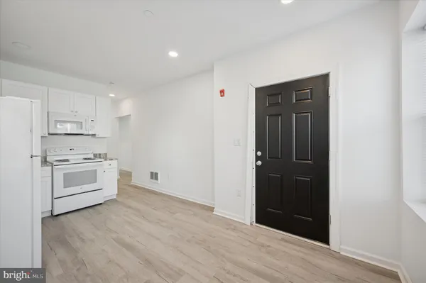 a kitchen with white cabinets and white appliances