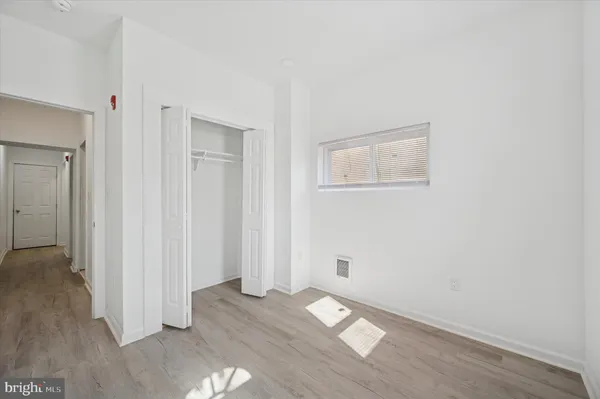an empty room with wooden floor and closet