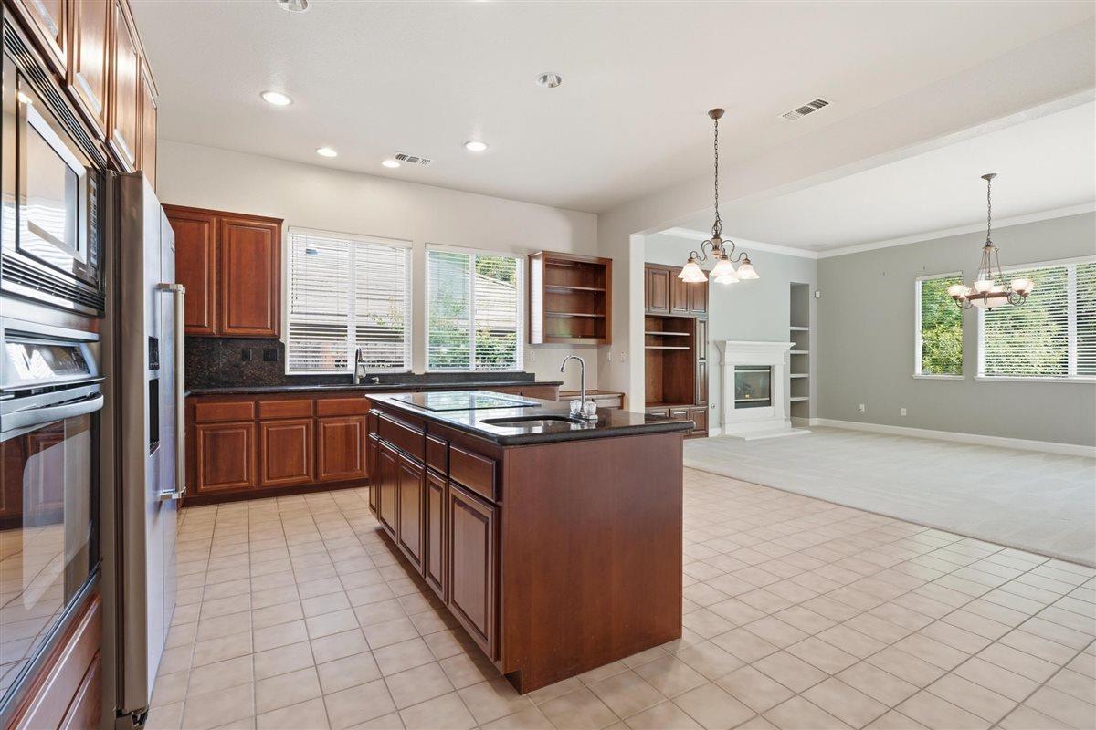 4129 Poppleton Way Carmichael, CA 95608 - Photo 12 of 48 a large kitchen with stainless steel appliances granite countertop a stove and a sink