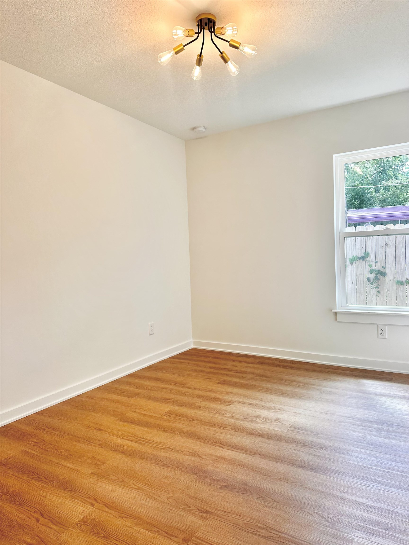 723 West 6th Street St. Augustine, FL 32084 - Photo 11 of 14 a view of an empty room with wooden floor and a window