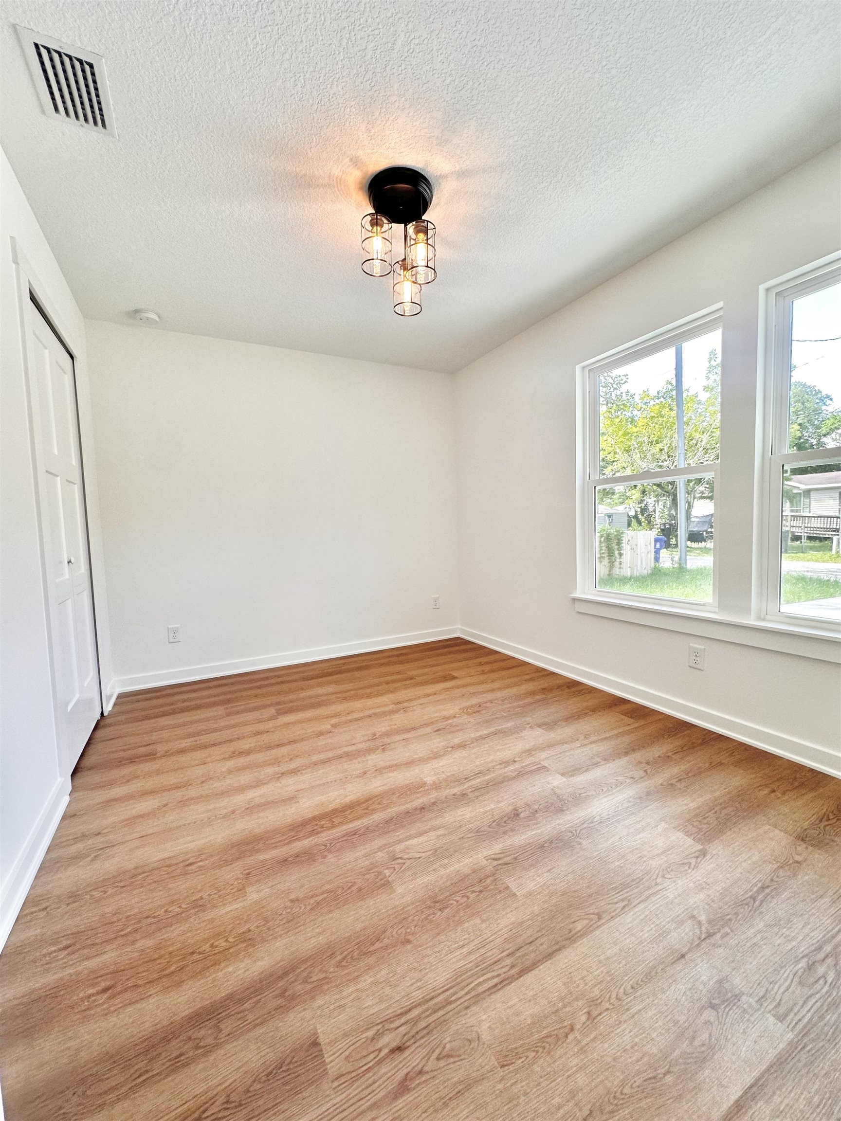 723 West 6th Street St. Augustine, FL 32084 - Photo 12 of 14 an empty room with wooden floor and windows