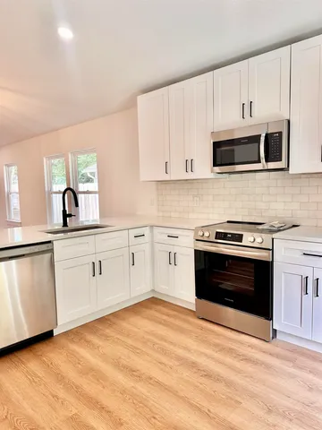 a kitchen with stainless steel appliances granite countertop a stove and a sink