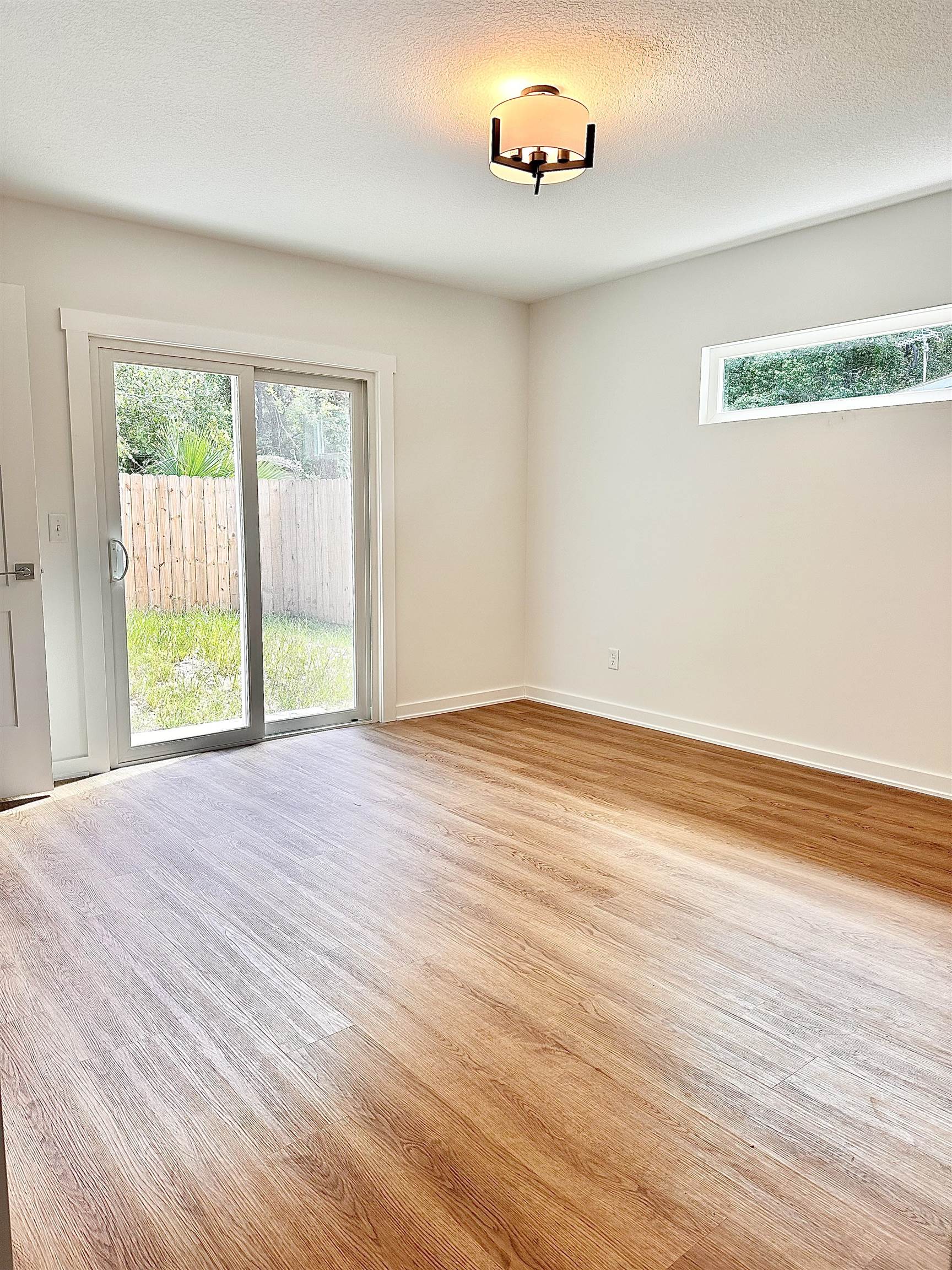 723 West 6th Street St. Augustine, FL 32084 - Photo 8 of 14 an empty room with wooden floor and windows