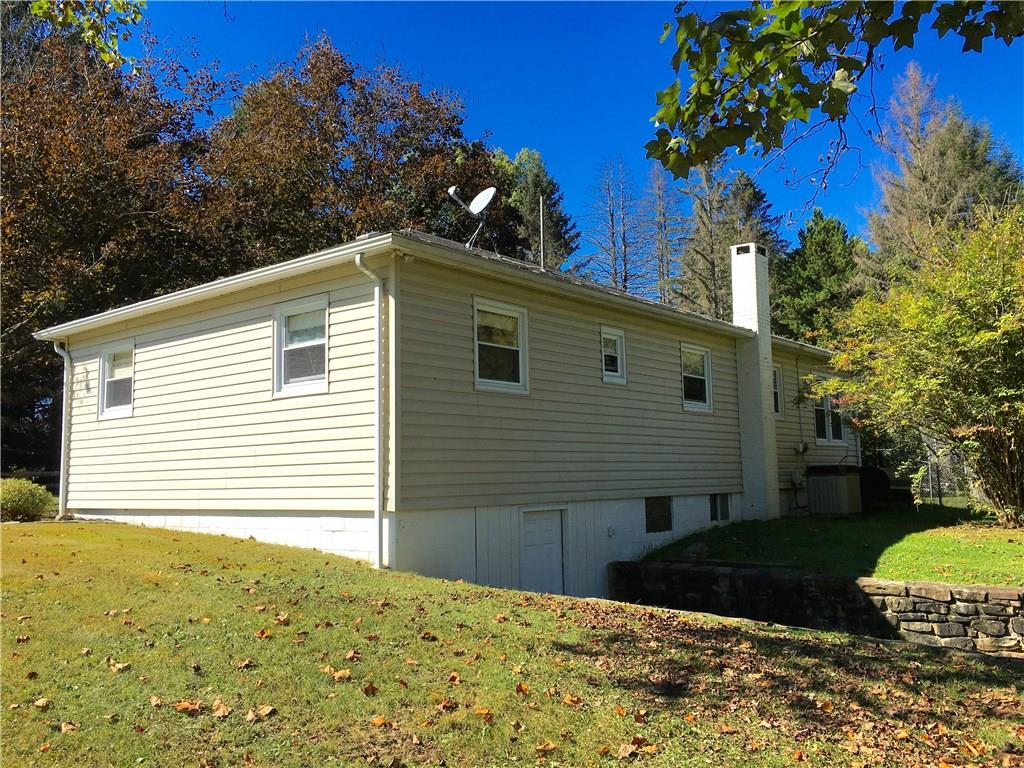 117 Azalea Lane Rector, PA 15677 - Photo 3 of 25 Nestled in the foothills of the Laurel Highlands and in the midst of wonderful natural places to connect with nature and the soul. You may notice at one time there was a single car integral garage that has since been converted to a man door.