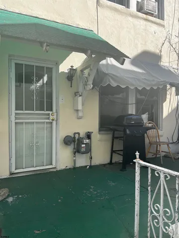 a view of a chair and table in backyard of the house