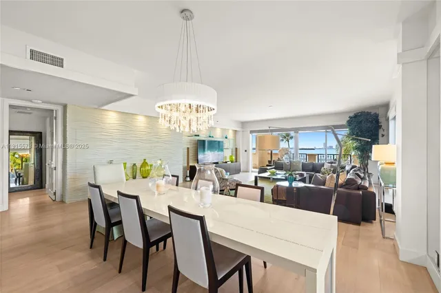 a view of a dining room and livingroom furniture a chandelier and wooden floor