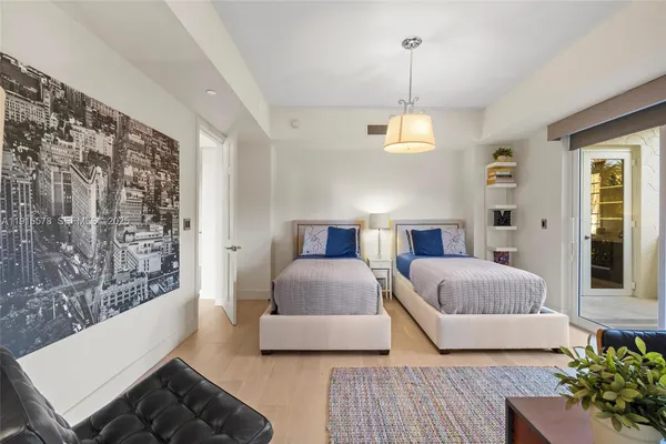 a spacious bedroom with a bed a couch and a large window