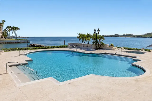 a view of a white house with a big yard and palm trees
