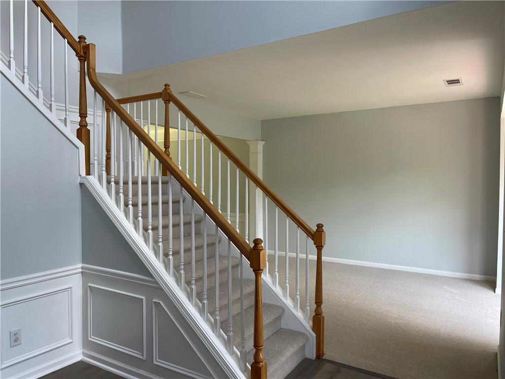 3118 Stanstead Court Norcross, GA 30071 - Photo 4 of 14 a view of staircase with wooden floor and white walls