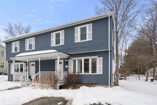 a front view of a house with a yard covered in snow