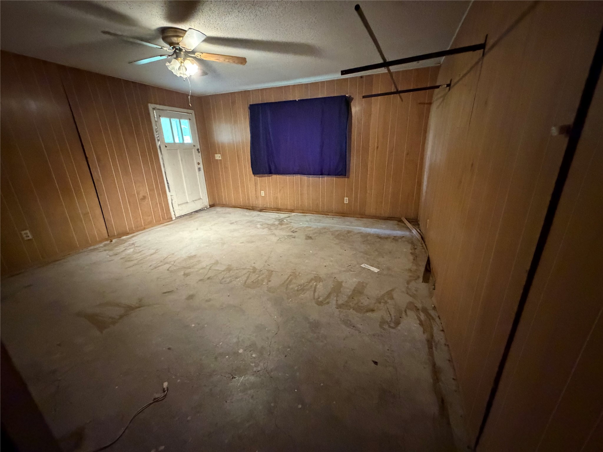 2501 Barnhardt Road Temple, TX 76502 - Photo 15 of 25 A spacious room awaits transformation with paneling and a ceiling fan.