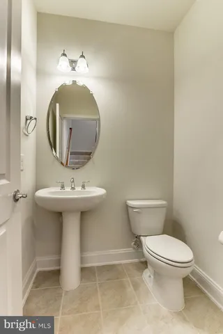 a bathroom with a toilet a sink and mirror