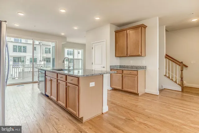 a large kitchen with stainless steel appliances granite countertop a stove a sink and a wooden floors