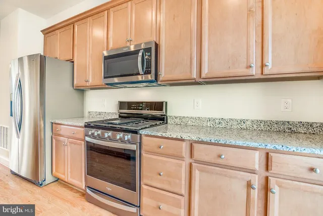 a kitchen with stainless steel appliances granite countertop a stove microwave and refrigerator