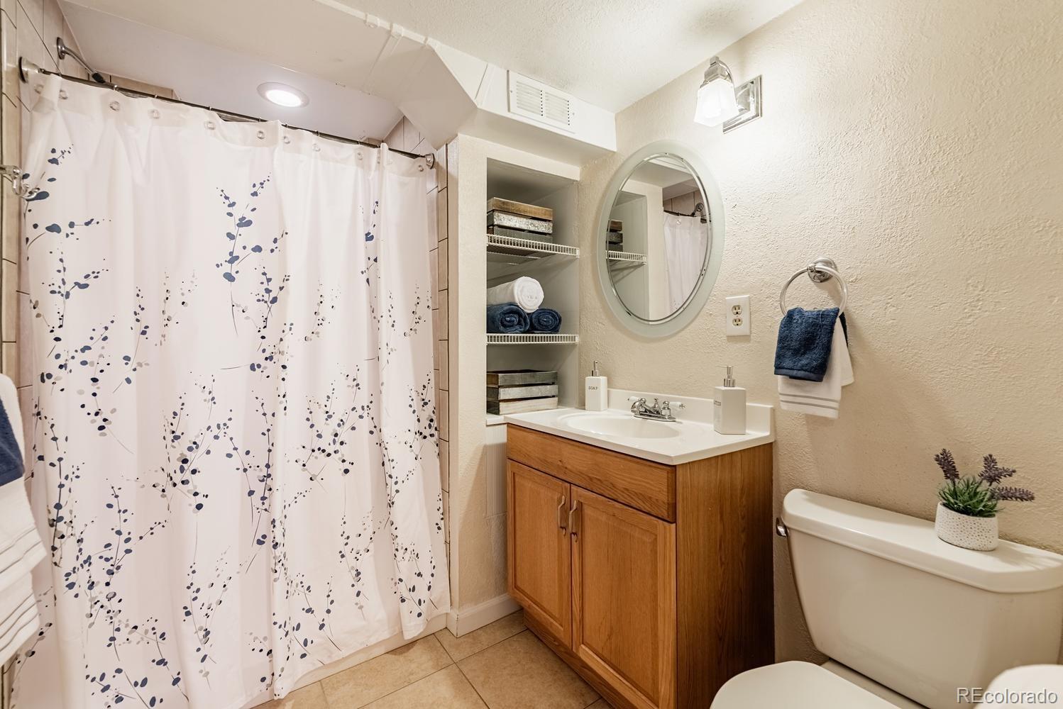 13895 Braun Road Golden, CO 80401 - Photo 24 of 40 a bathroom with a toilet sink vanity granite and a shower