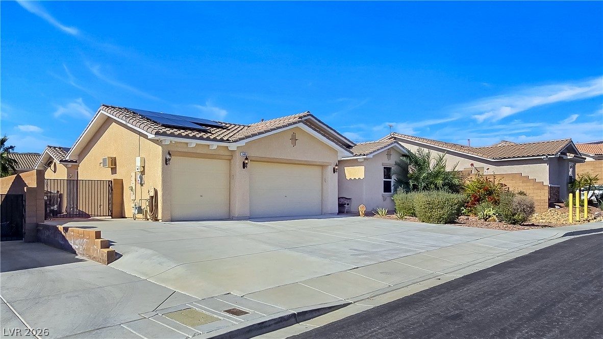 2485 Morrow Ridge Place Laughlin, NV 89029 - Photo 3 of 40 A well-maintained desert home with attached garages and a xeriscaped front yard.
