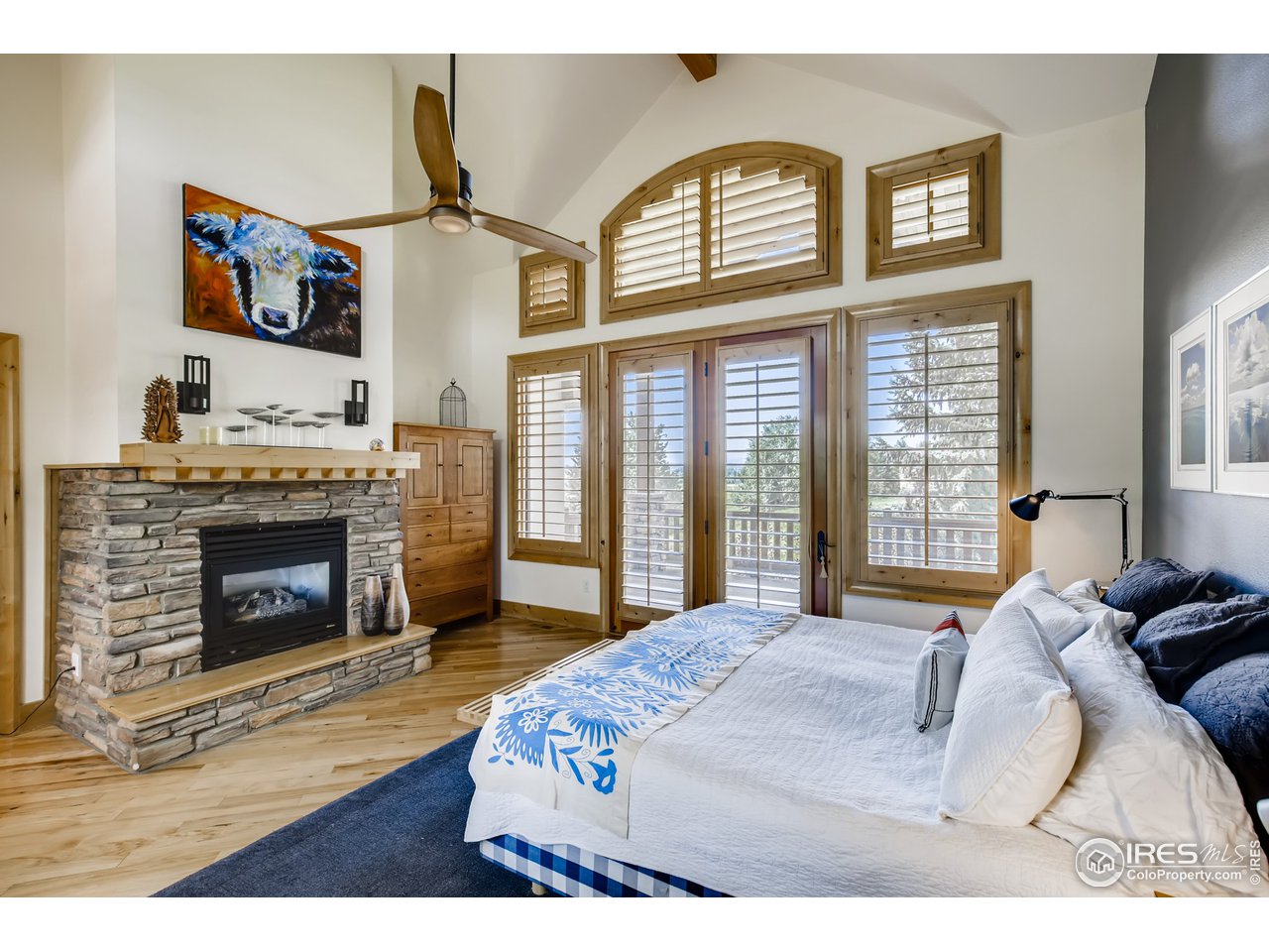 10484 Sunlight Drive Lafayette, CO 80026 - Photo 20 of 40 a bedroom with a bed a fireplace and a large window