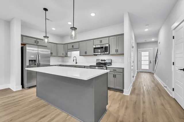 a kitchen with kitchen island a sink stainless steel appliances and cabinets