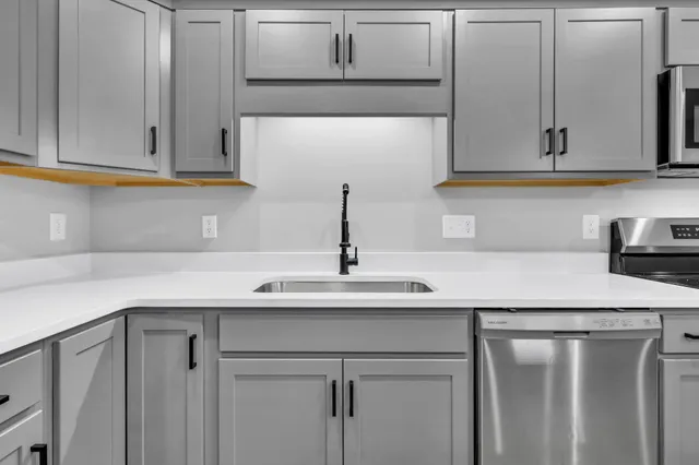 a kitchen with stainless steel appliances white cabinets and a sink